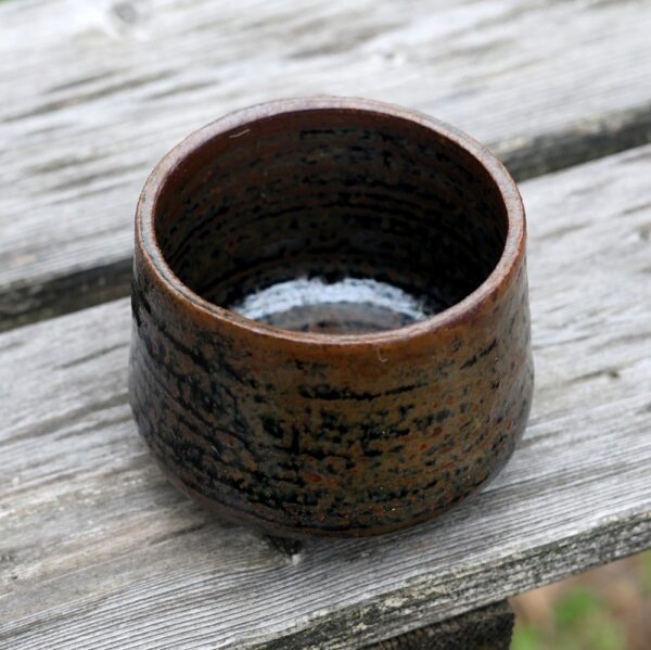 Le Bol à matcha en grès - réf 84 repose sur une surface en bois patiné, mettant en valeur la beauté intemporelle de l'artisanat. - Atelier Terre et Bois à Colmar