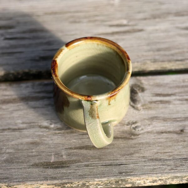 La tasse avec anse - grès - réf 6 repose sur une surface en bois patiné, vue de dessus. - Atelier Terre et Bois à Colmar